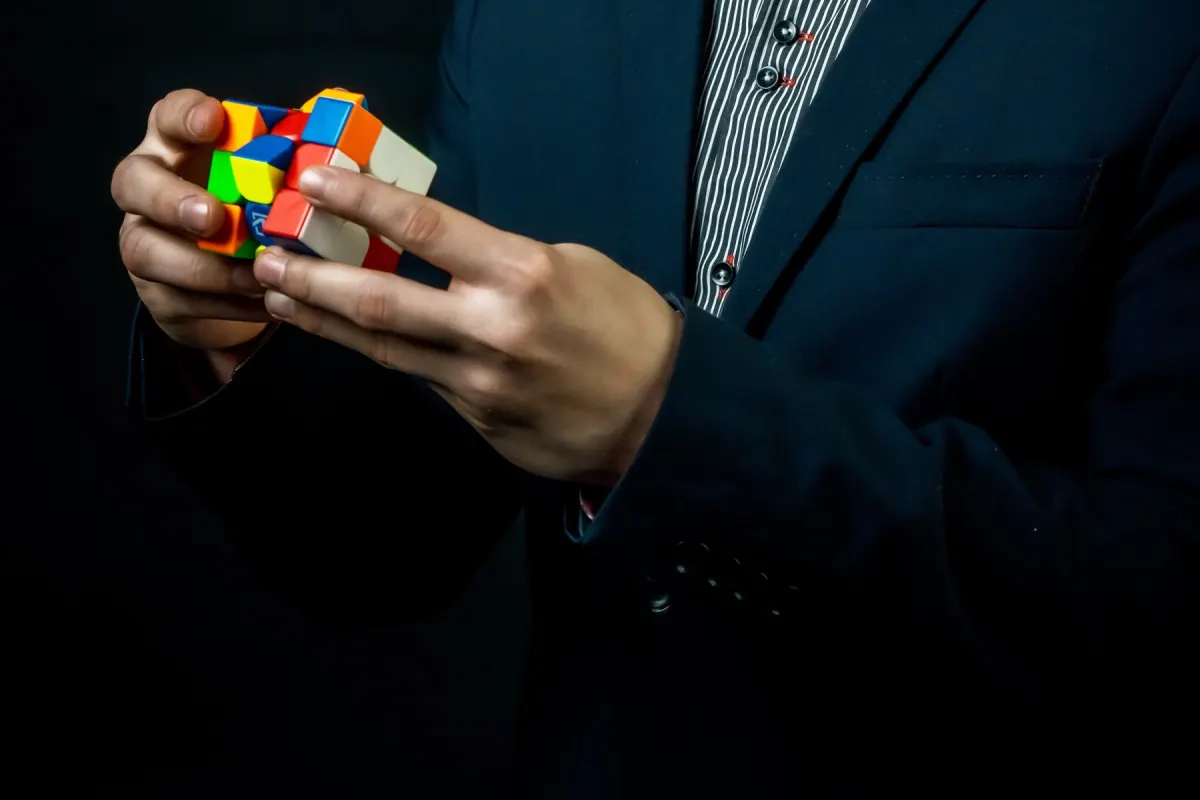 Due mani girano un cubo di Rubik a metà, con i colori ancora mescolati.