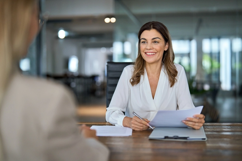 Colloquio HR di selezione tra due professioniste in un ambiente di ufficio, con ascolto attivo e attenzione non giudicante