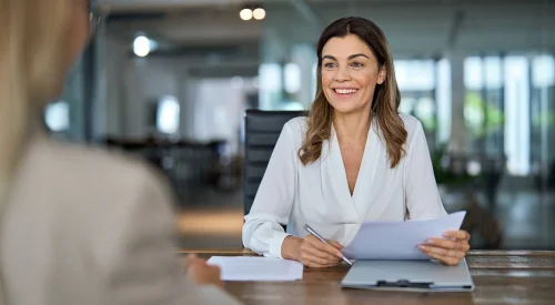 Colloquio HR di selezione tra due professioniste in un ambiente di ufficio, con ascolto attivo e attenzione non giudicante